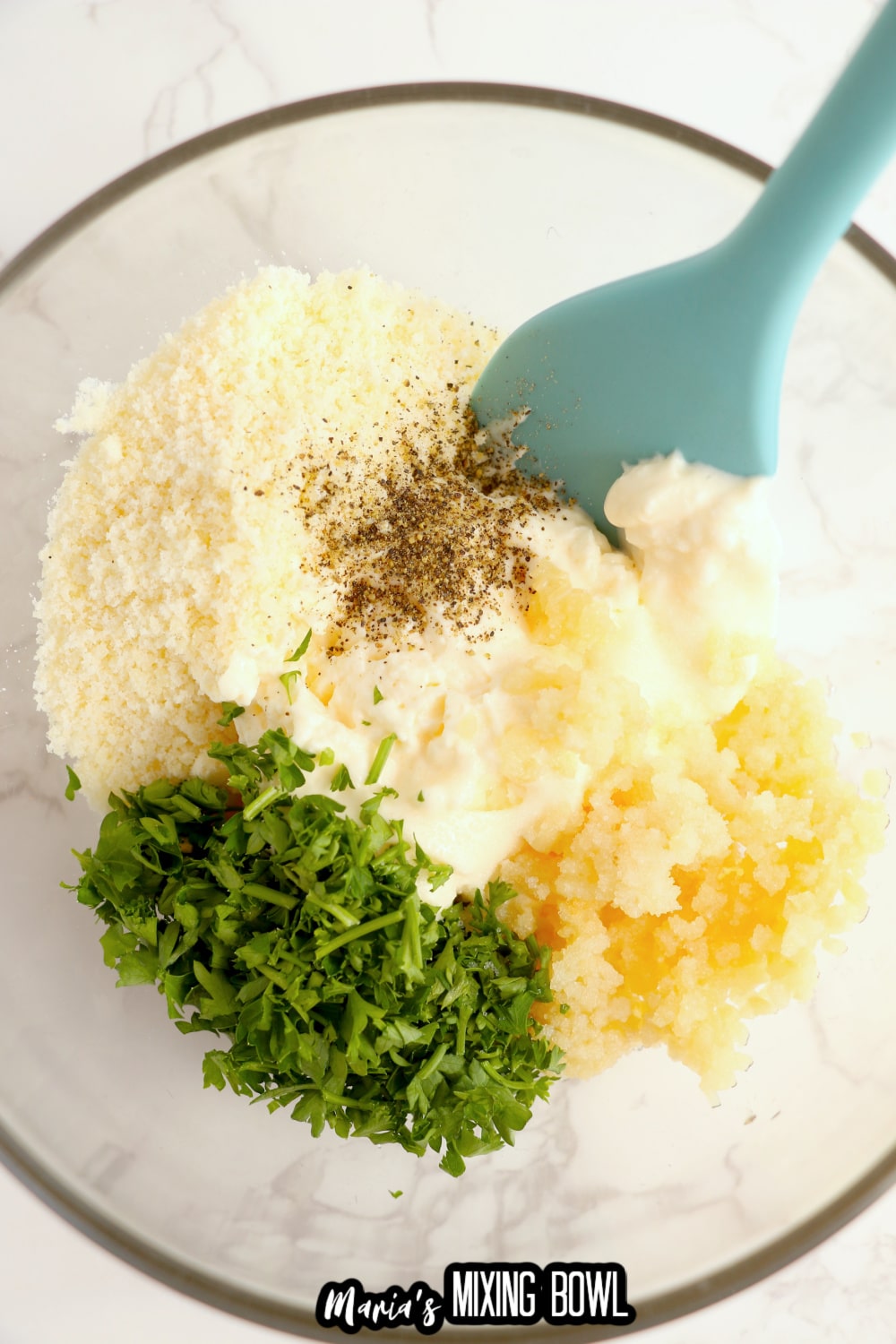 mayo, garlic, parmesan cheese, black pepper in a glass mixing bowl