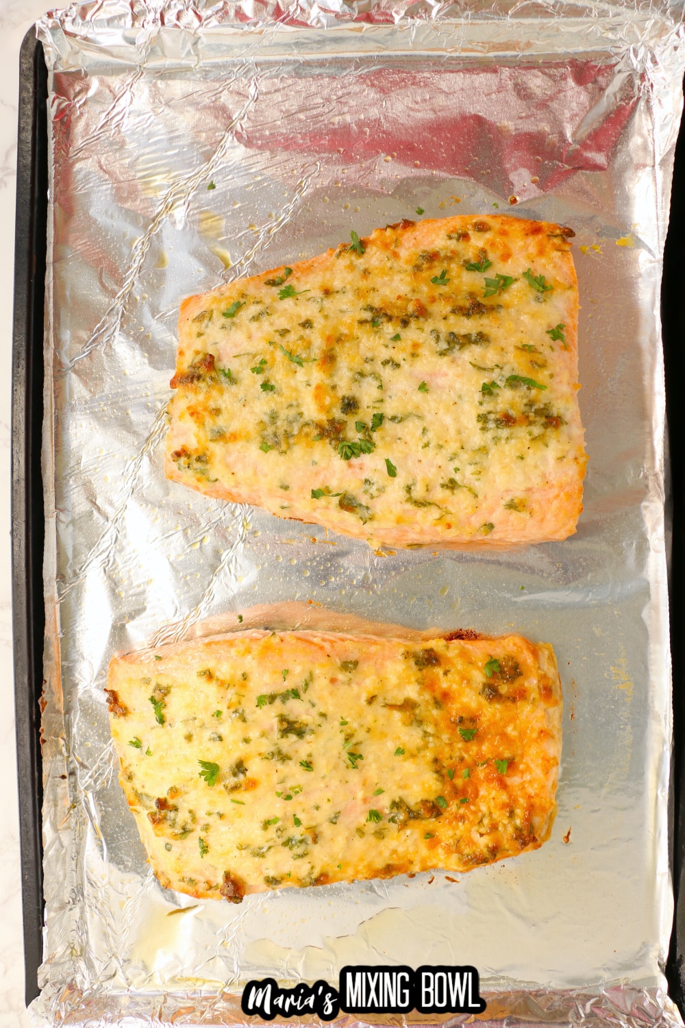 baked salmon on a foil lined baking sheet
