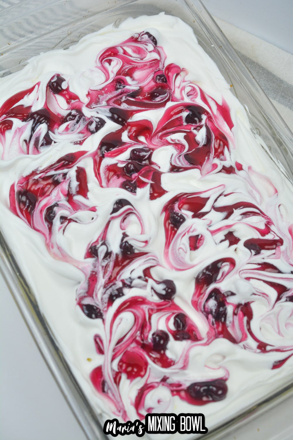 whipped topping swirled with blueberry pie filling in a glass baking dish
