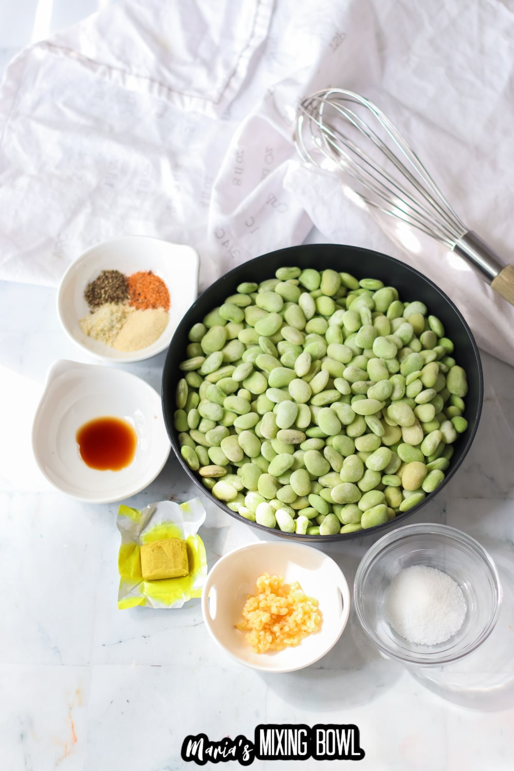 seasonings, bullion, garlic, and lima beans on a white linen background