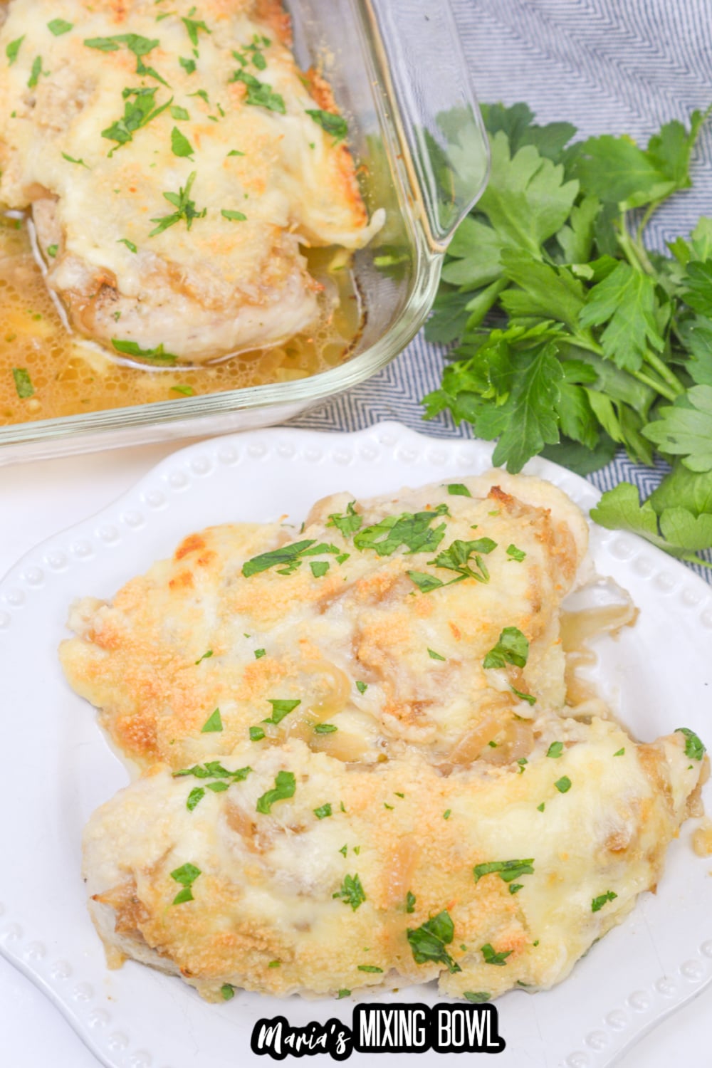 two pieces of french onion chicken on a white plate