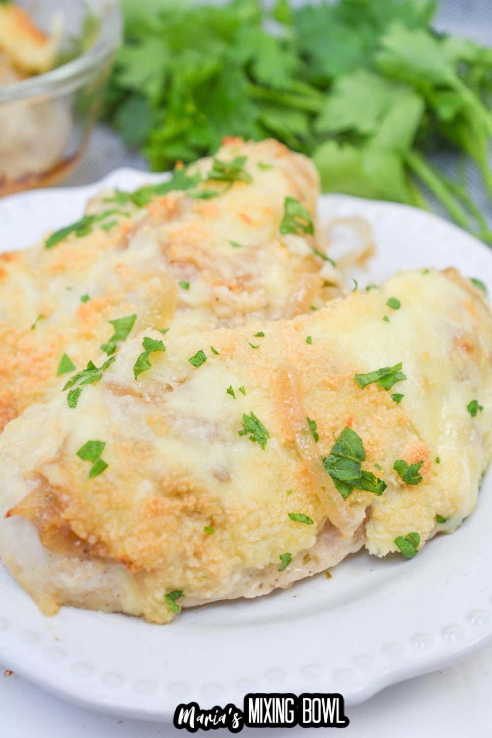 two pieces of french onion chicken on a white plate