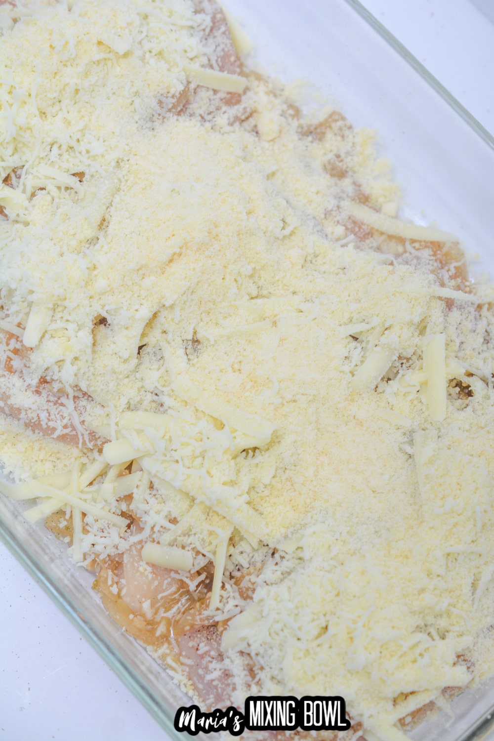 chicken, onions and cheese in a glass baking dish