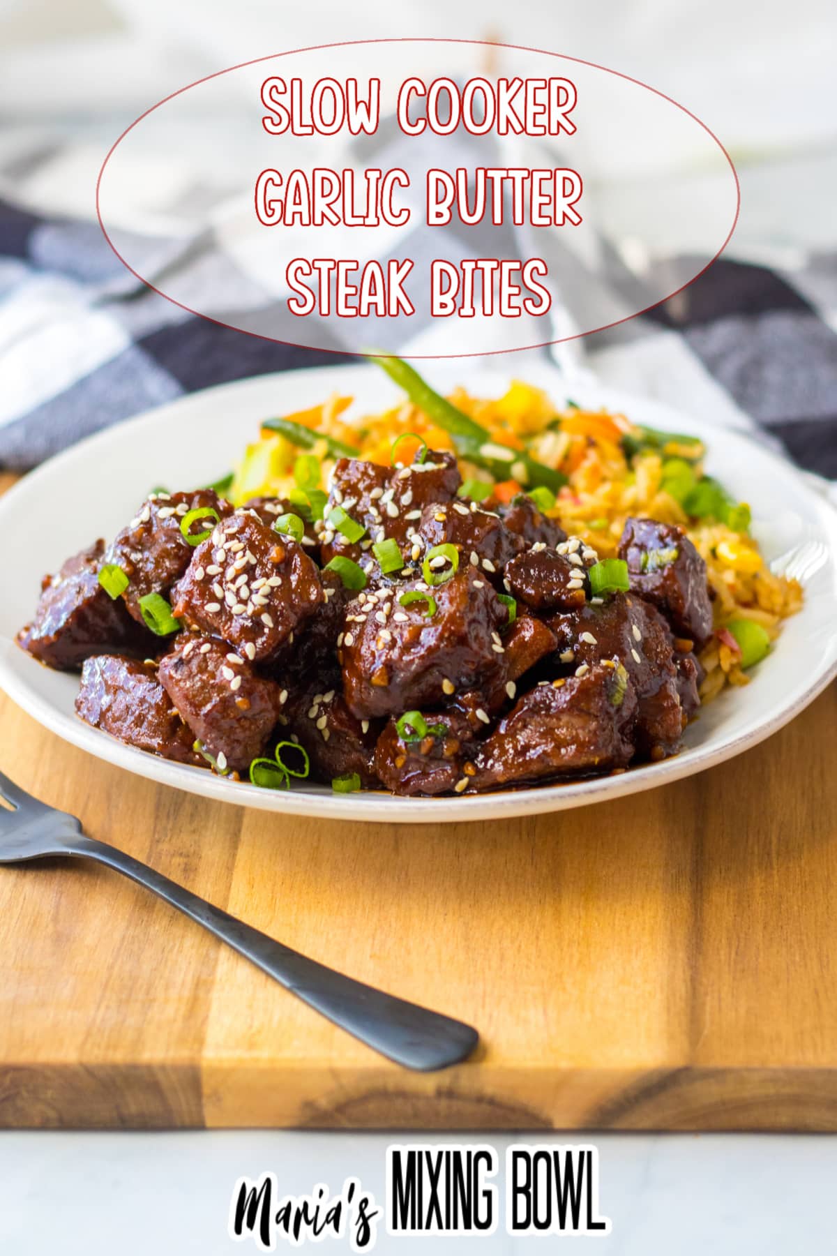 garlic butter steak bites on a white plate with a side of rice