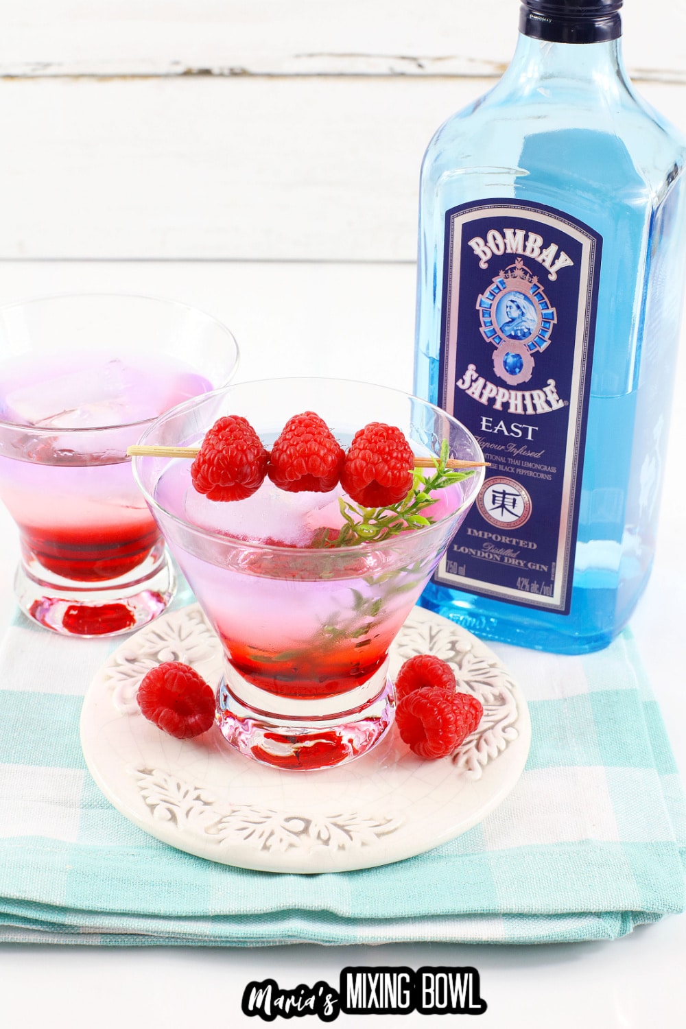 gin berry cocktail in a cocktail glass garnished with raspberries on a toothpick