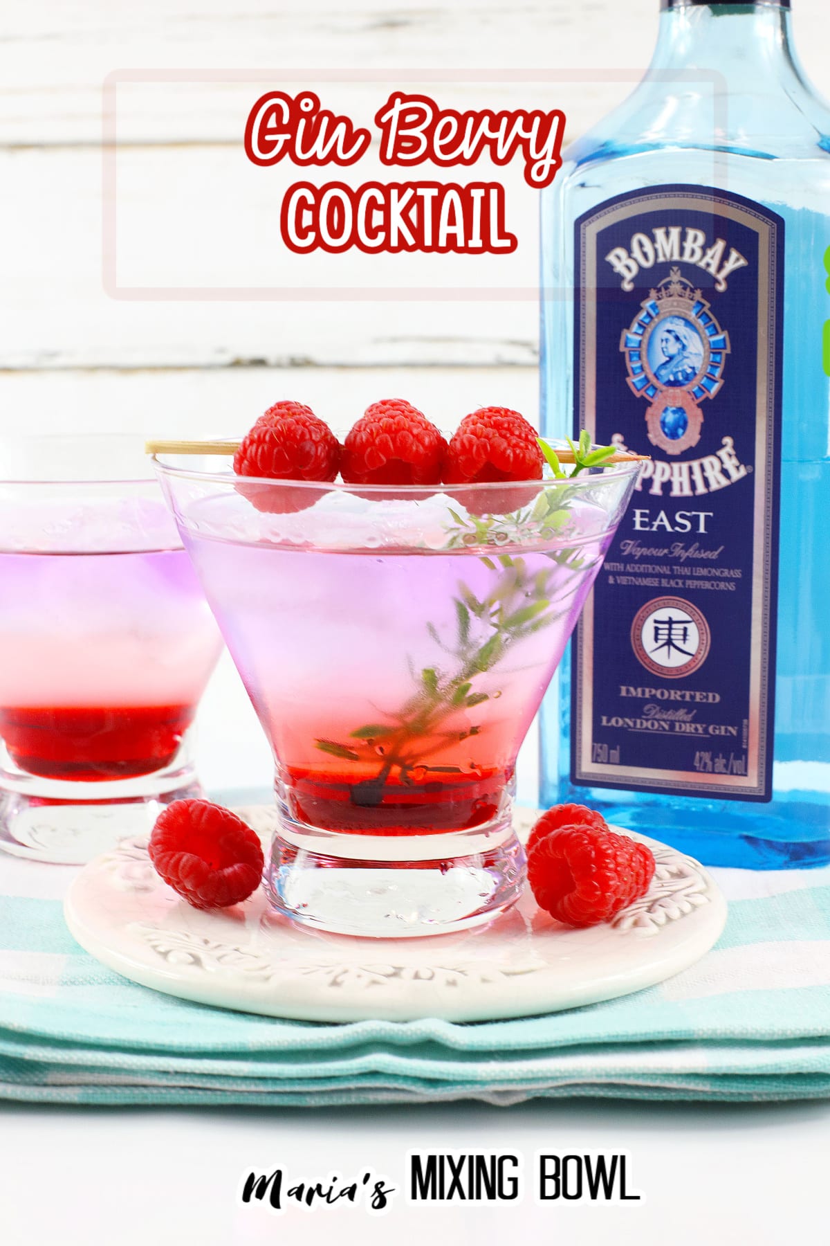 gin berry cocktail in a cocktail glass garnished with raspberries on a toothpick
