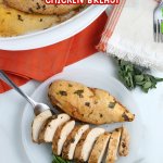 two chicken breasts on a plate. One is sliced and one is whole