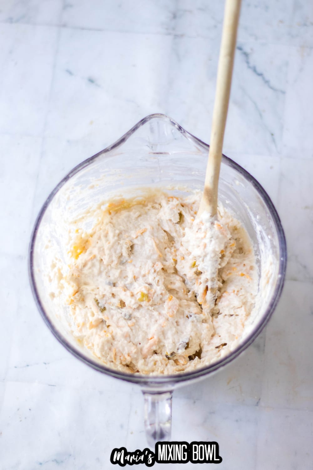 biscuit batter in large mixing bowl with a wooden spoon