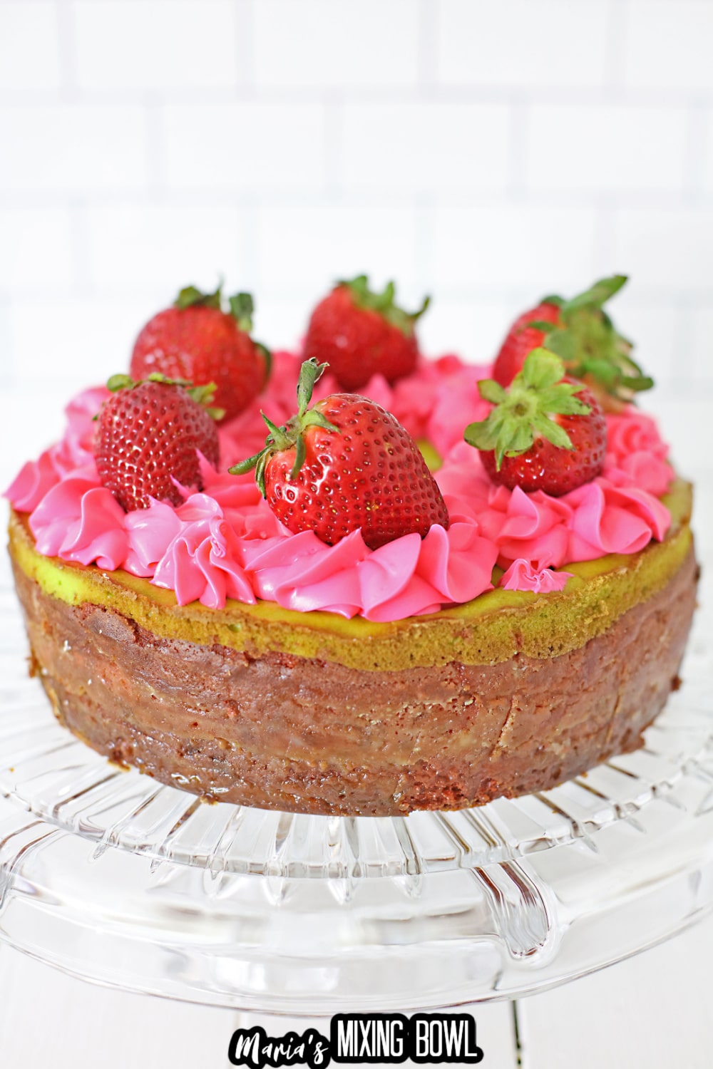 uncut key lime strawberry cheesecake cake on a cake stand