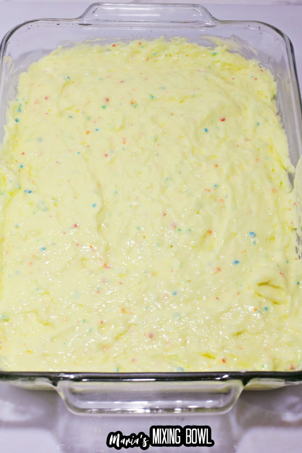 cake mix in a glass baking dish on a white counter