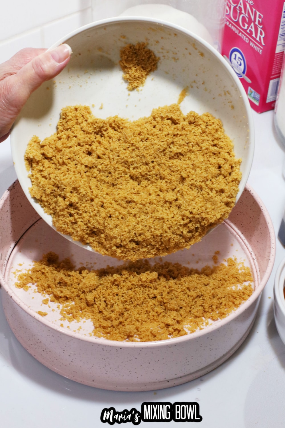 graham crackers and butter being pressed into a springform pan