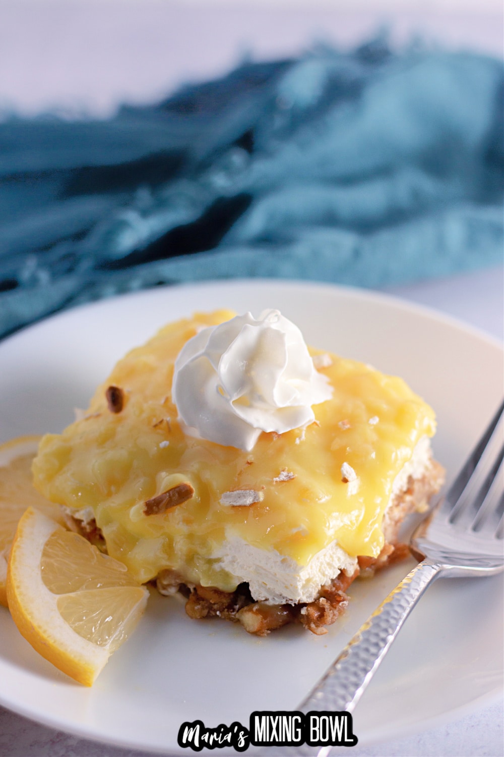 slice of pineapple pretzel salad on a white plate with a sliver fork.