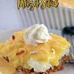 slice of pineapple pretzel salad on a white plate with a sliver fork.