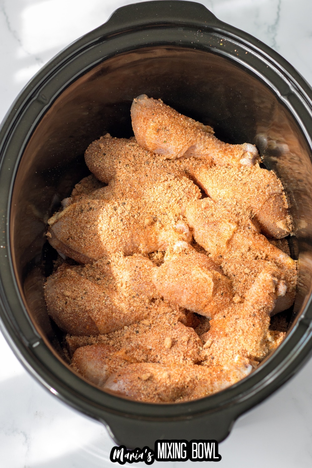 raw chicken and seasonings in the slow cooker