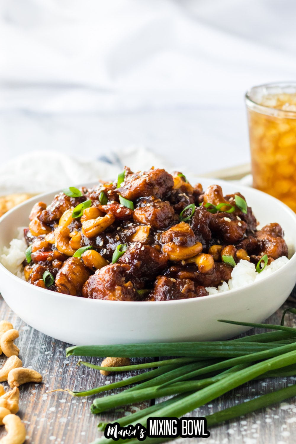 a white bowl filled with slow cooker cashew chicken and white rice