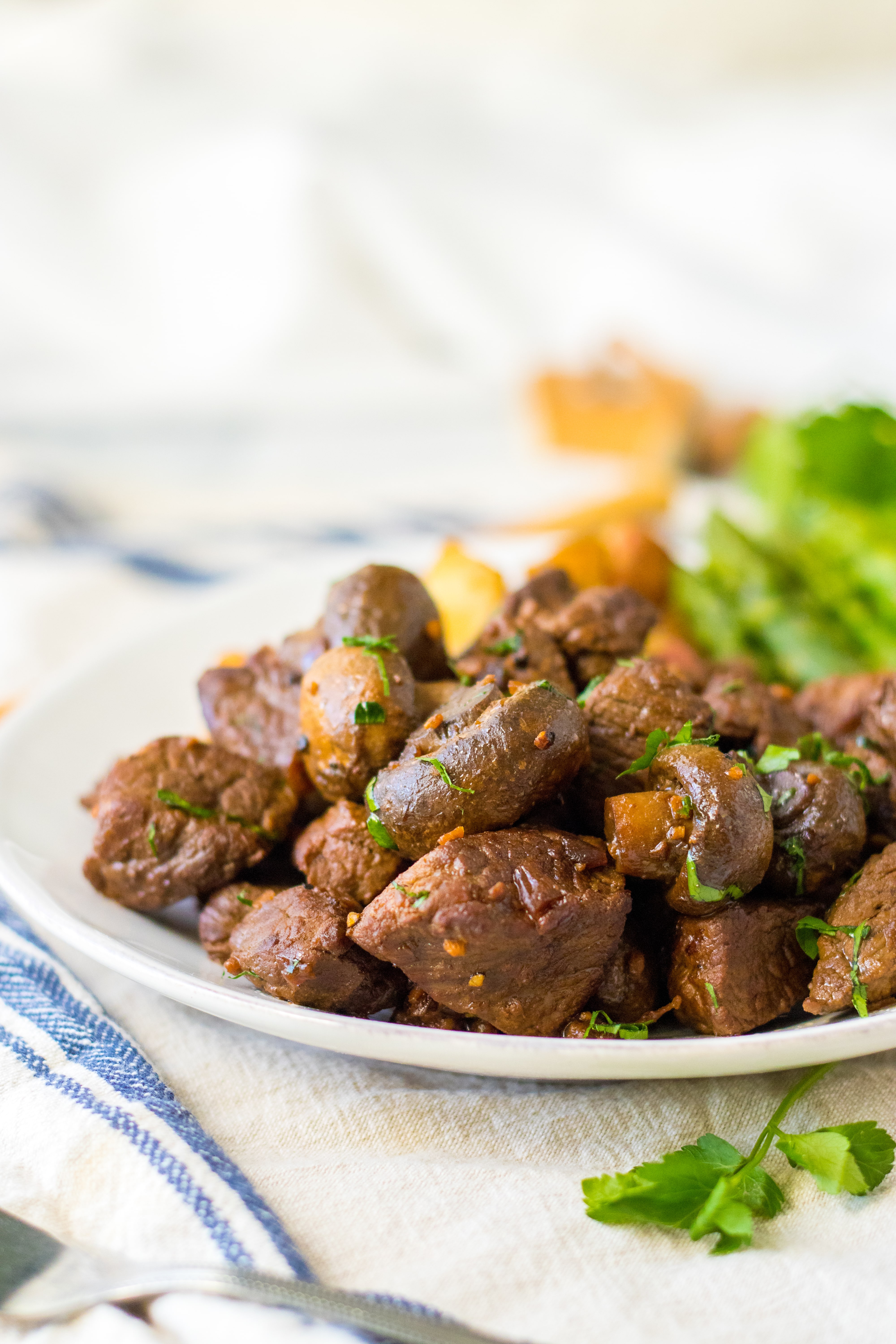 white plate filled with mushroom steak bites on a white plate