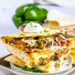 three slow cooker quesadillas stacked on a white plate