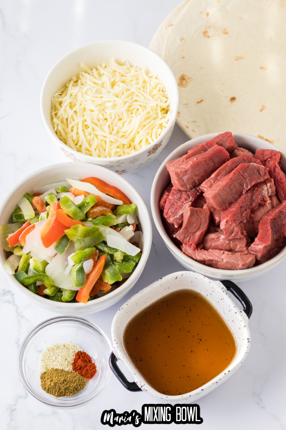 bowls of peppers and onions, beef, cheese, seasonings, and tortillas on a white background