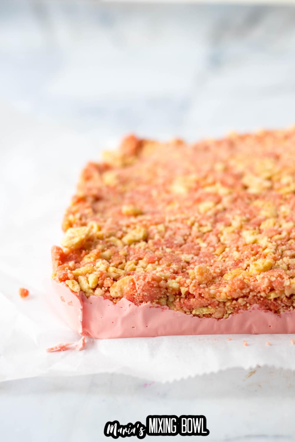 strawberry shortcake fudge on parchment paper about to be cut