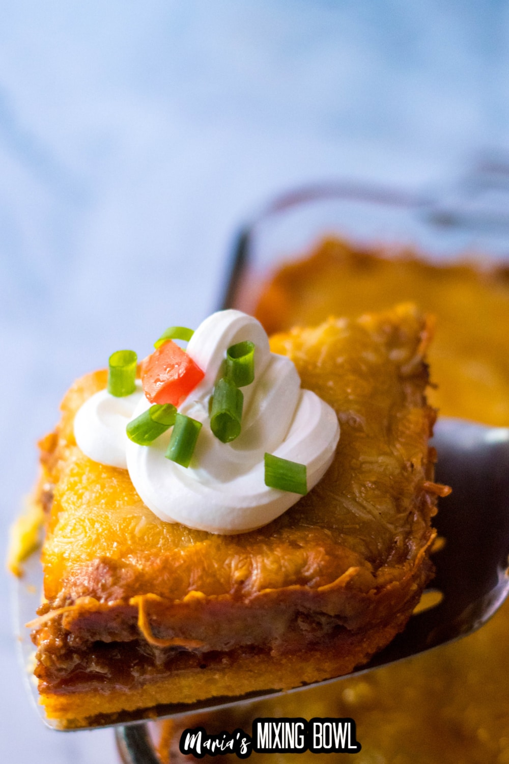slice of tamale casserole on a metal spatula held in the air