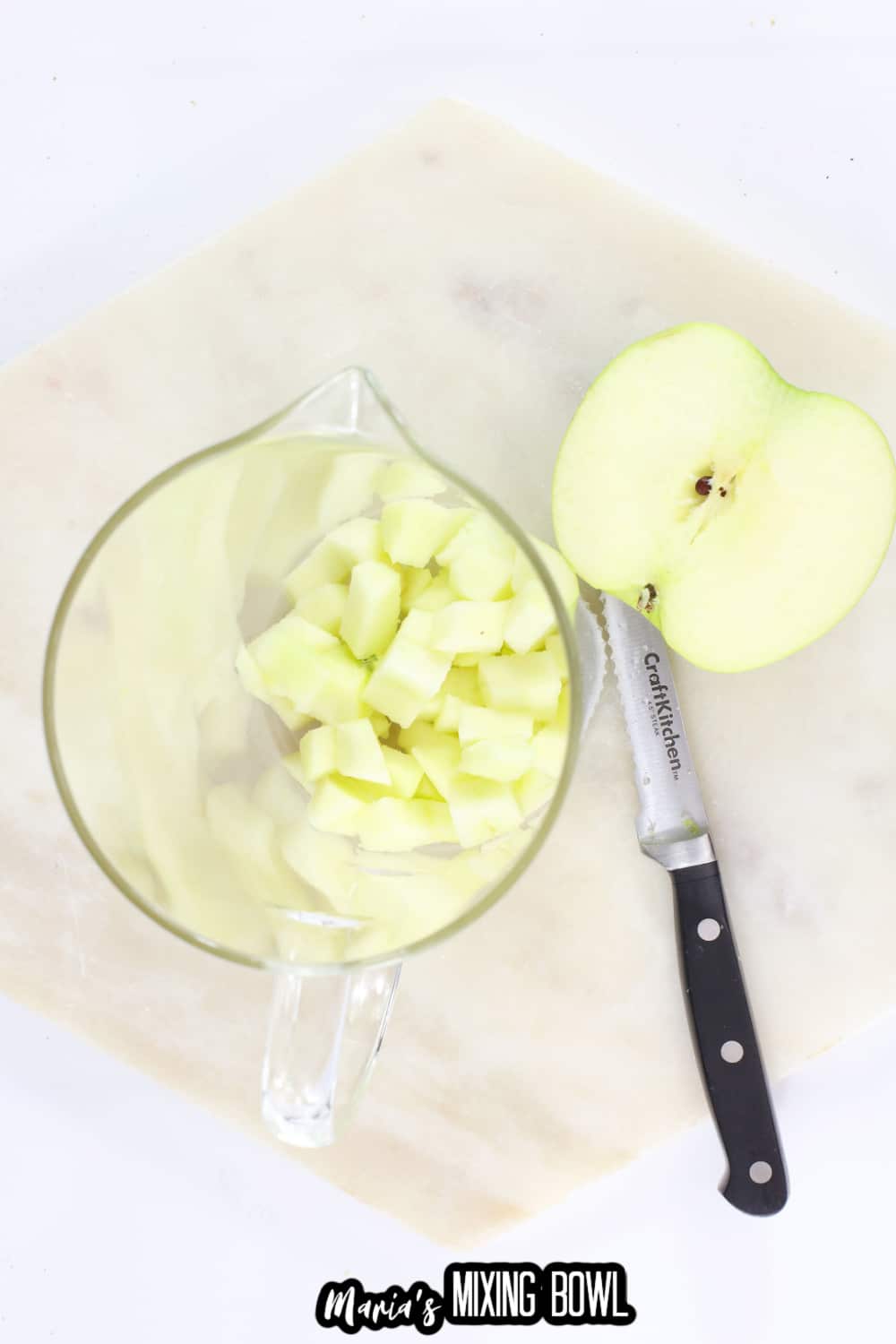 apple being chopped and added to a pitcher