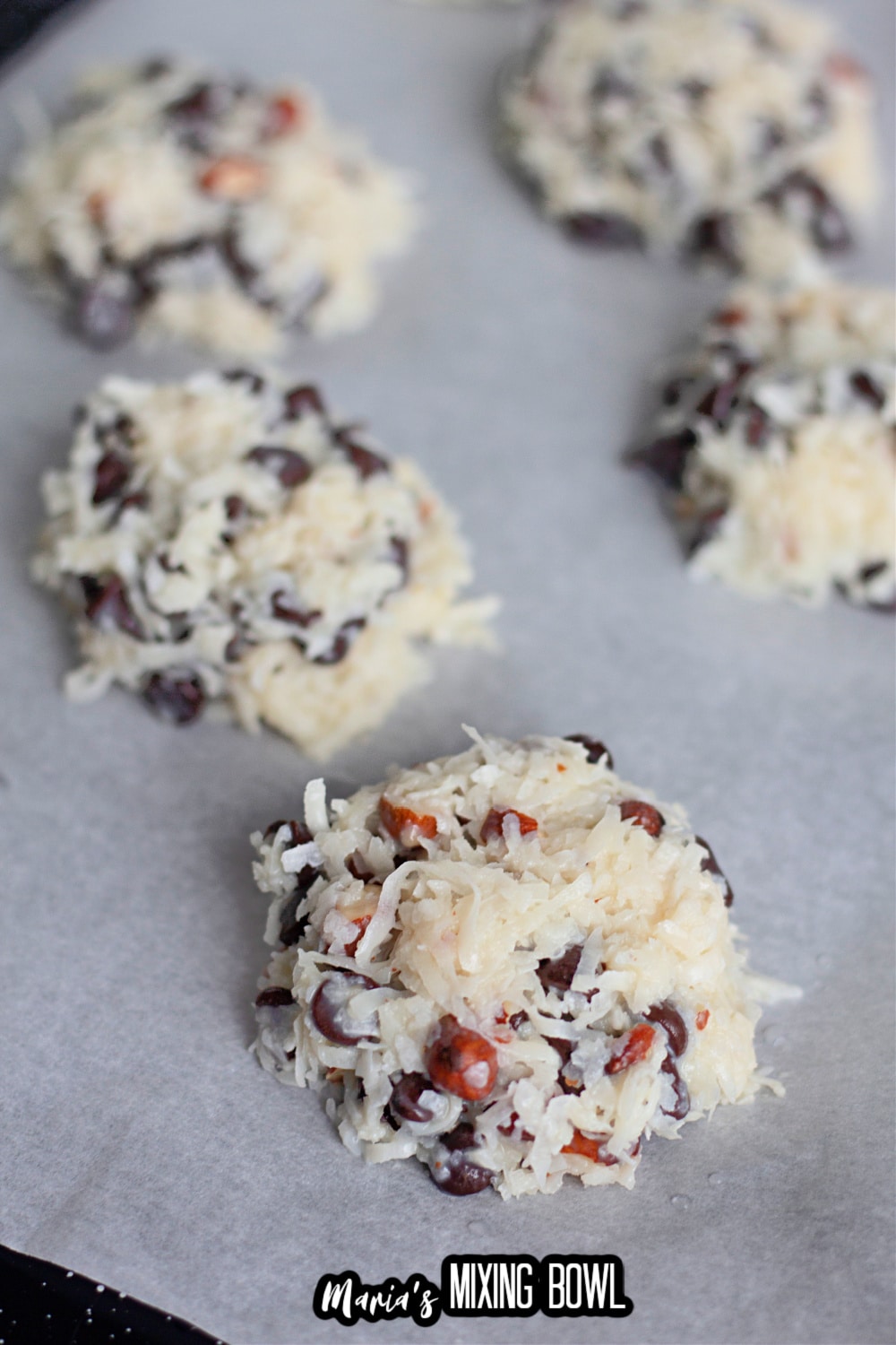 almond joy cookies on parchment lined baking sheet