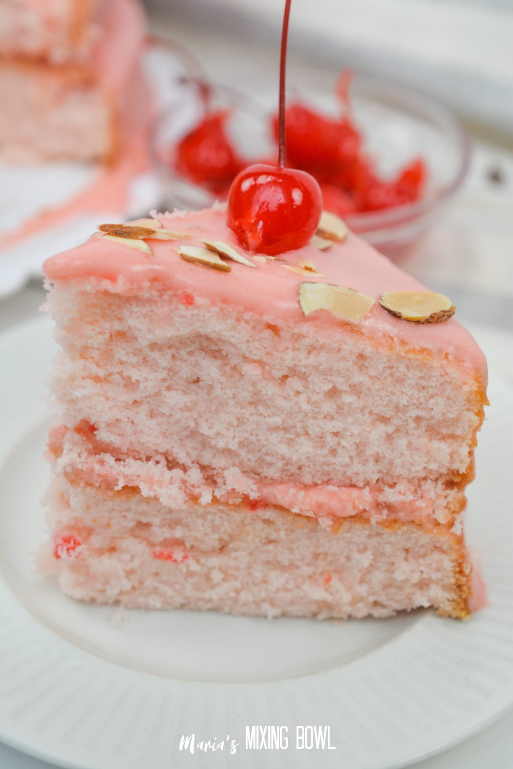 slice of cherry almond cake on a white plate