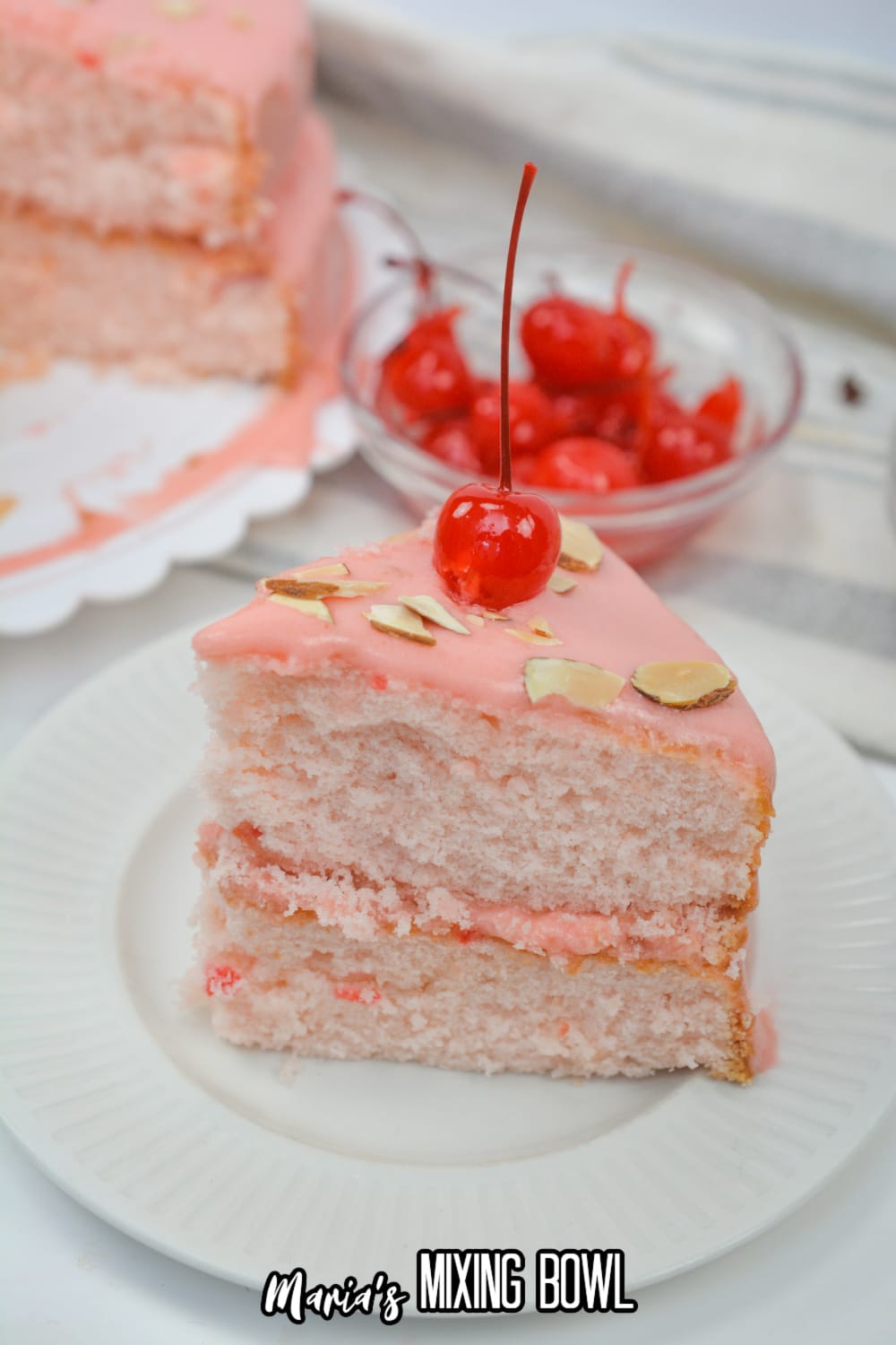 slice of cherry almond cake on a white plate