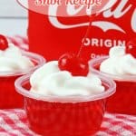 close up of cherry coke jello shots on a red and white kitchen towel