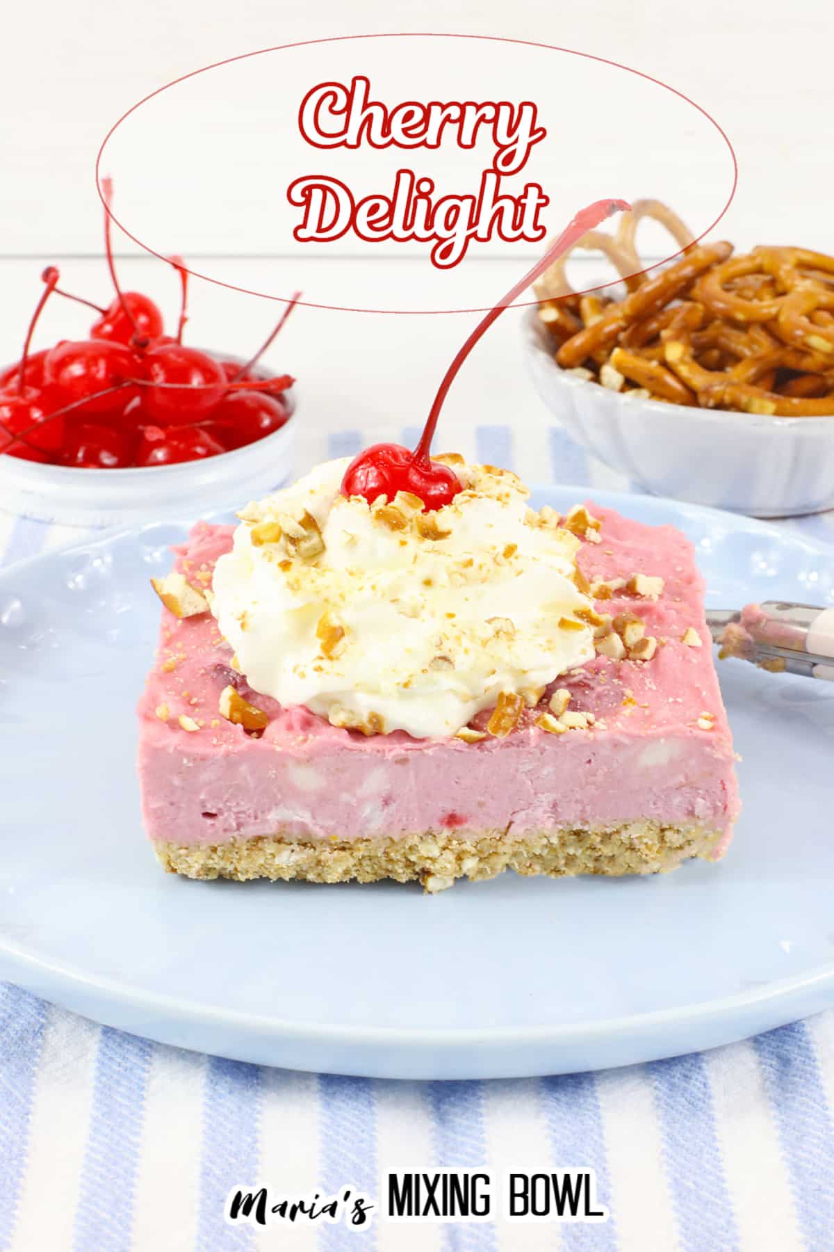 slice of cherry delight on a light blue plate topped with whipped cream and a cherry