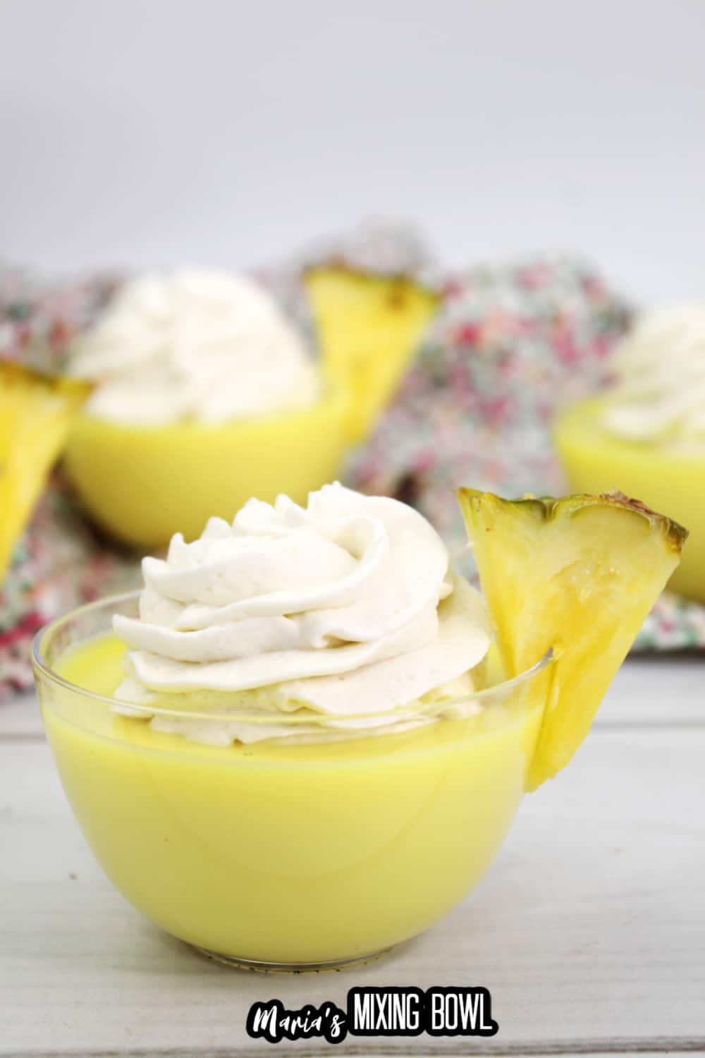 dole whip shot in a small glass bowl garnished with a slice of pineapple