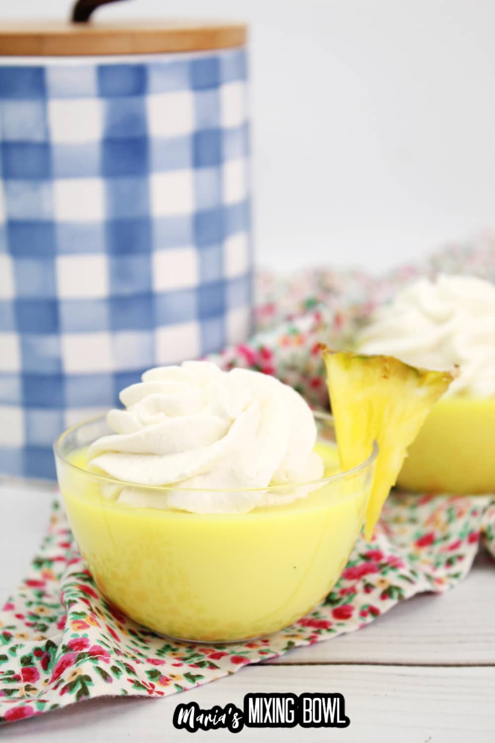 dole whip shot in a small glass bowl garnished with a slice of pineapple