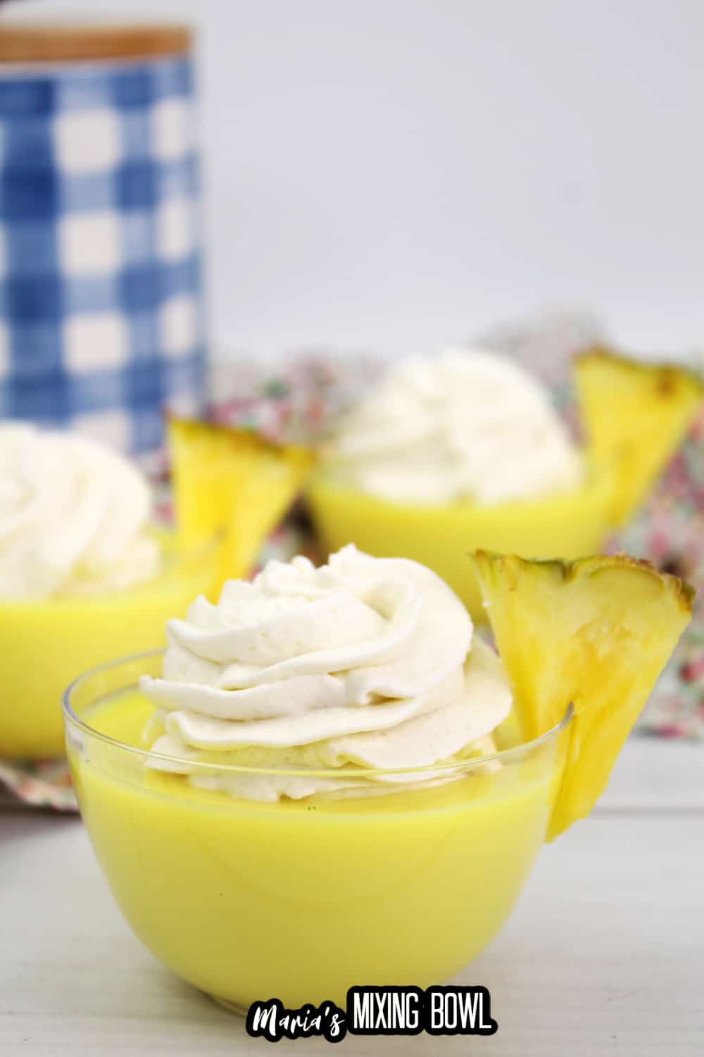 dole whip shot in a small glass bowl garnished with a slice of pineapple