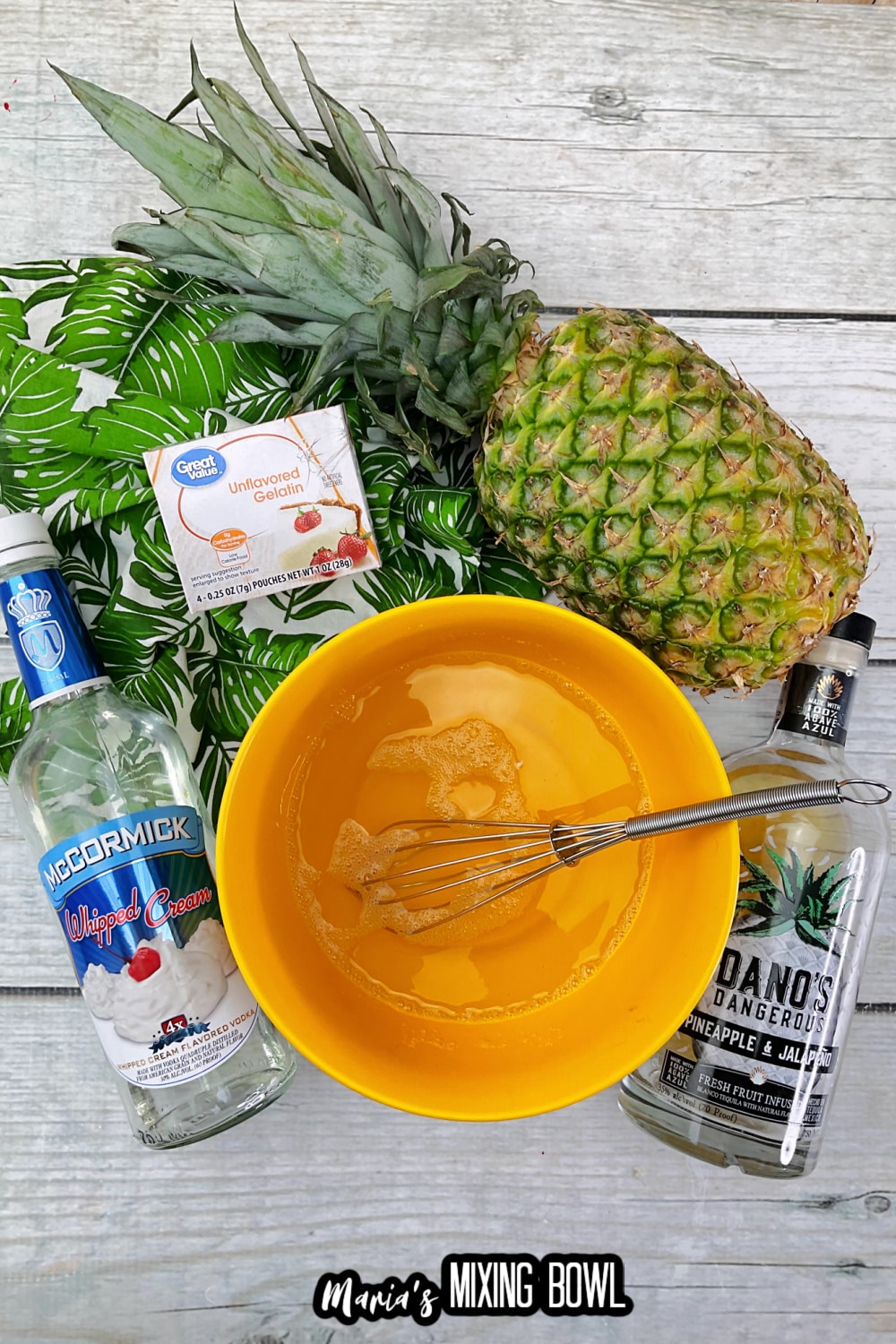 unflavored gelatin being mixed with water in an orange mixing bowl with a whisk