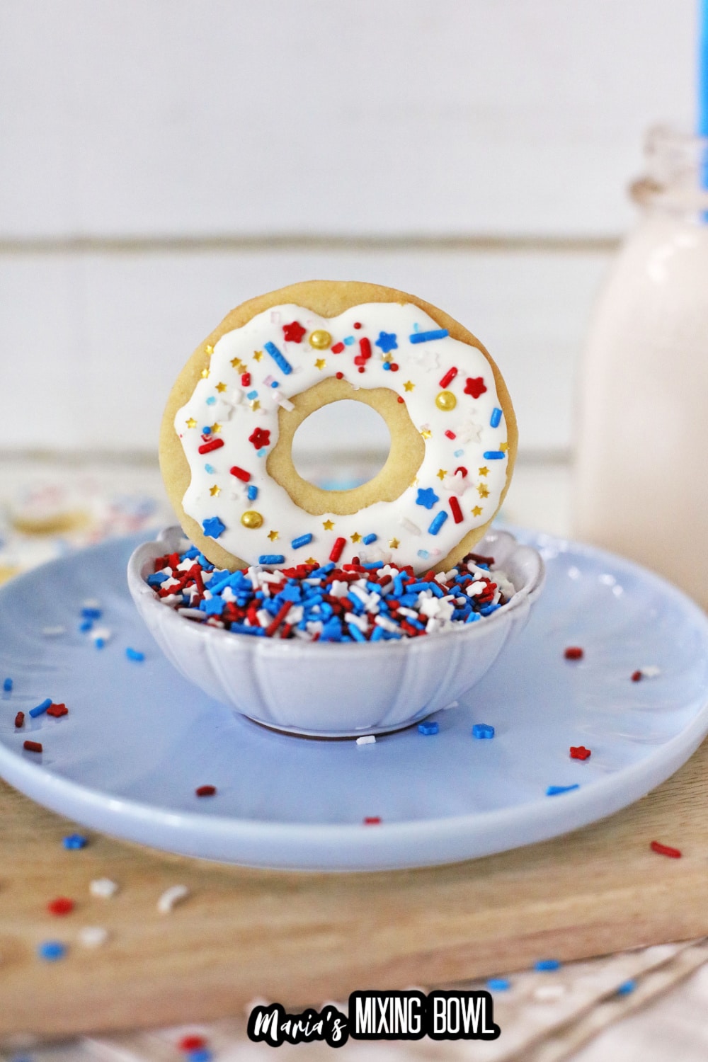 donut cookie standing in a bowl of sprinkles