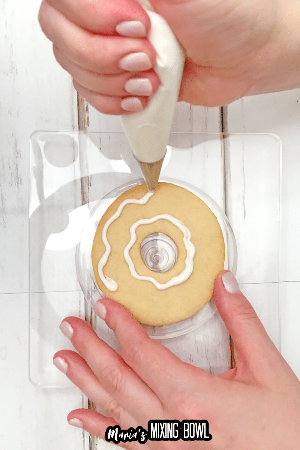 white frosting being piped onto a cookie