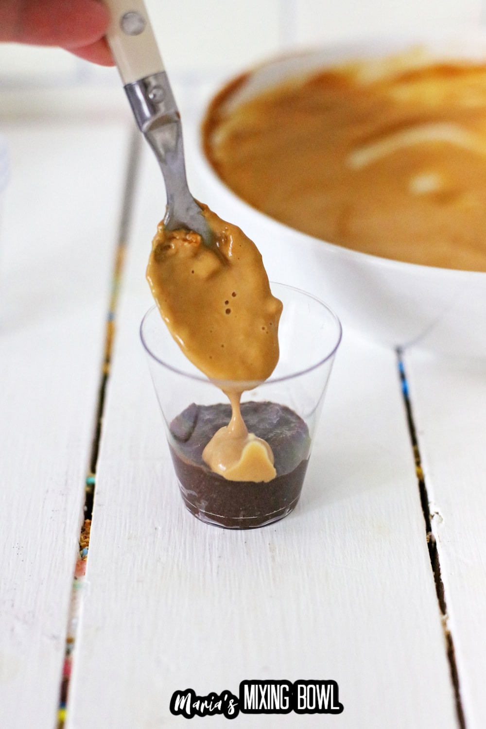 peanut butter layer being added to a shot glass