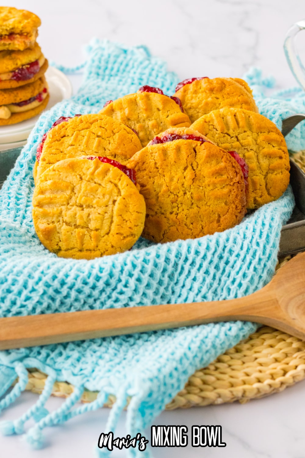 peanut butter and jelly cookies in a baking pan that is lined with a blue kitchen towels