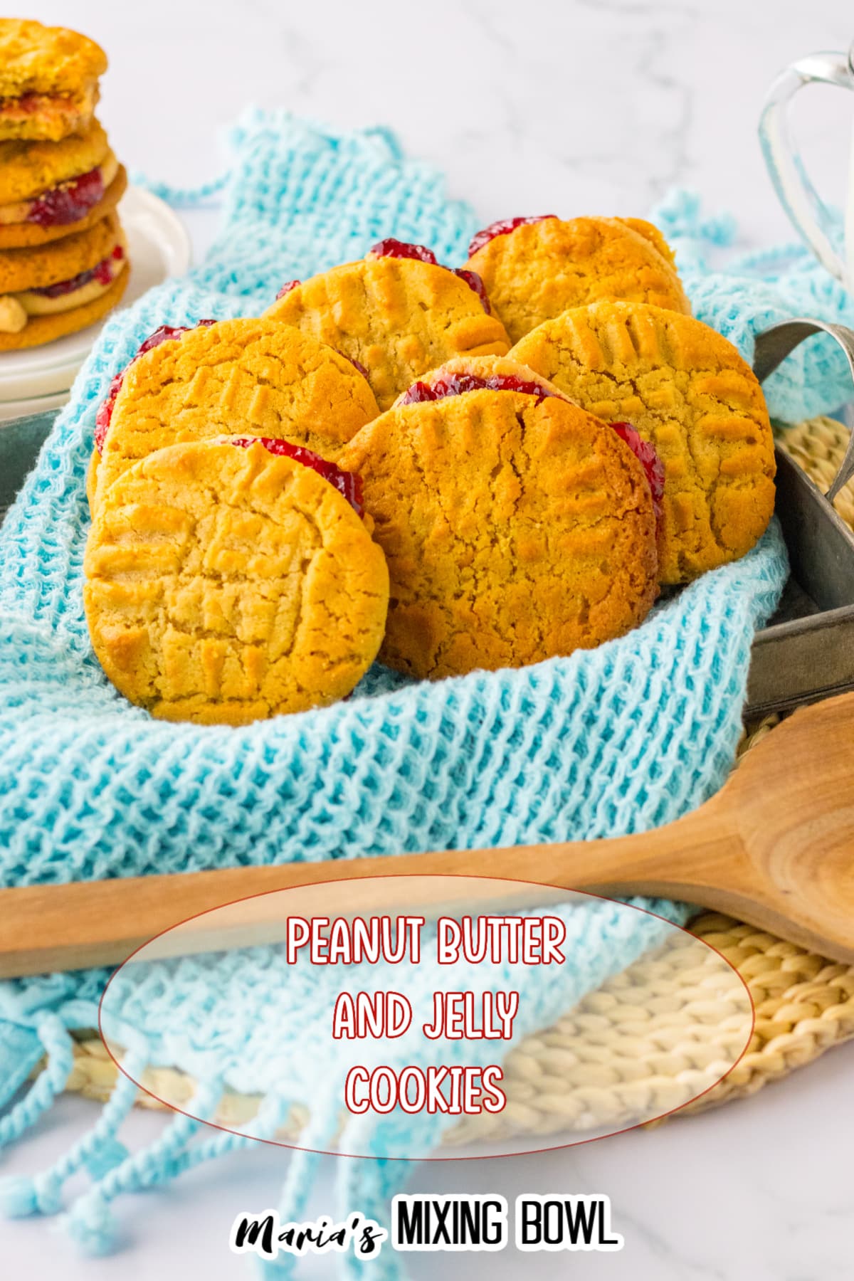 peanut butter and jelly cookies in a baking pan that is lined with a blue kitchen towels