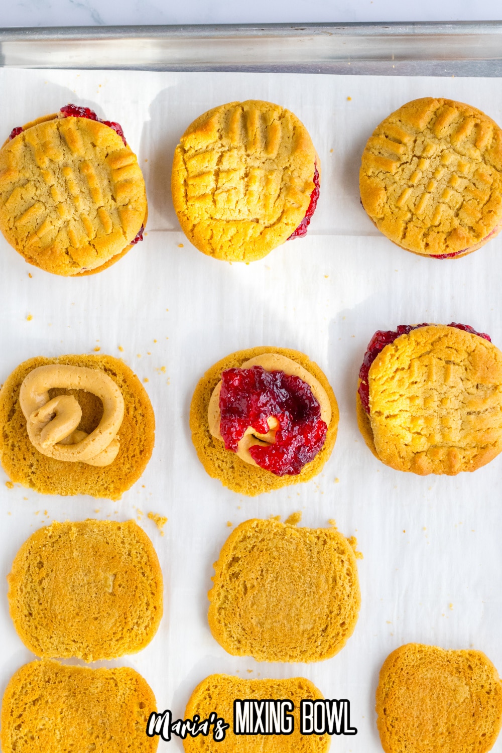 peanut butter cookies being filled with peanut butter and jelly