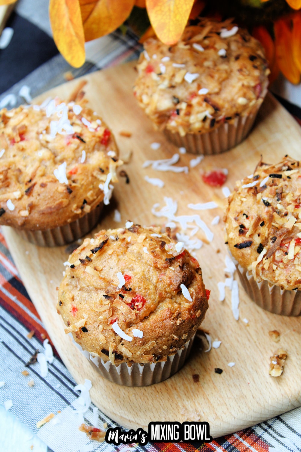 four muffins on a wooden cutting board