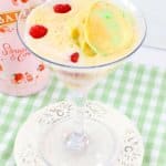 rainbow sherbet martini in a martini glass on a small white plate.