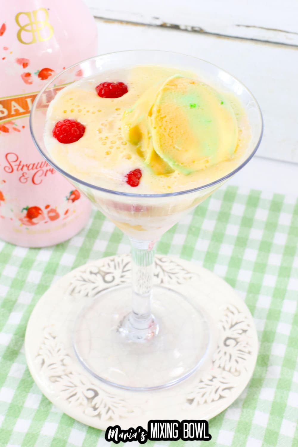 rainbow sherbet martini in a martini glass on a small white plate.
