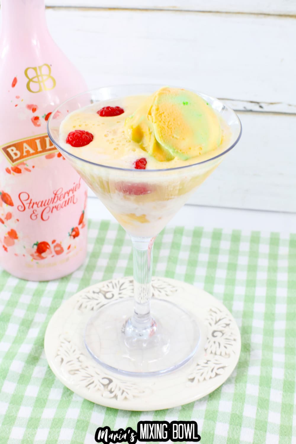 rainbow sherbet martini in a martini glass on a small white plate.