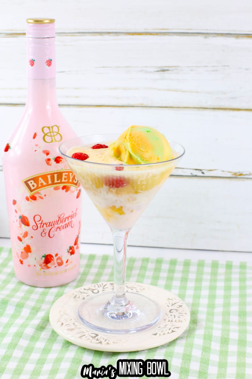 rainbow sherbet martini in a martini glass on a small white plate.