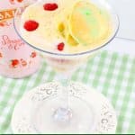 rainbow sherbet martini in a martini glass on a small white plate.
