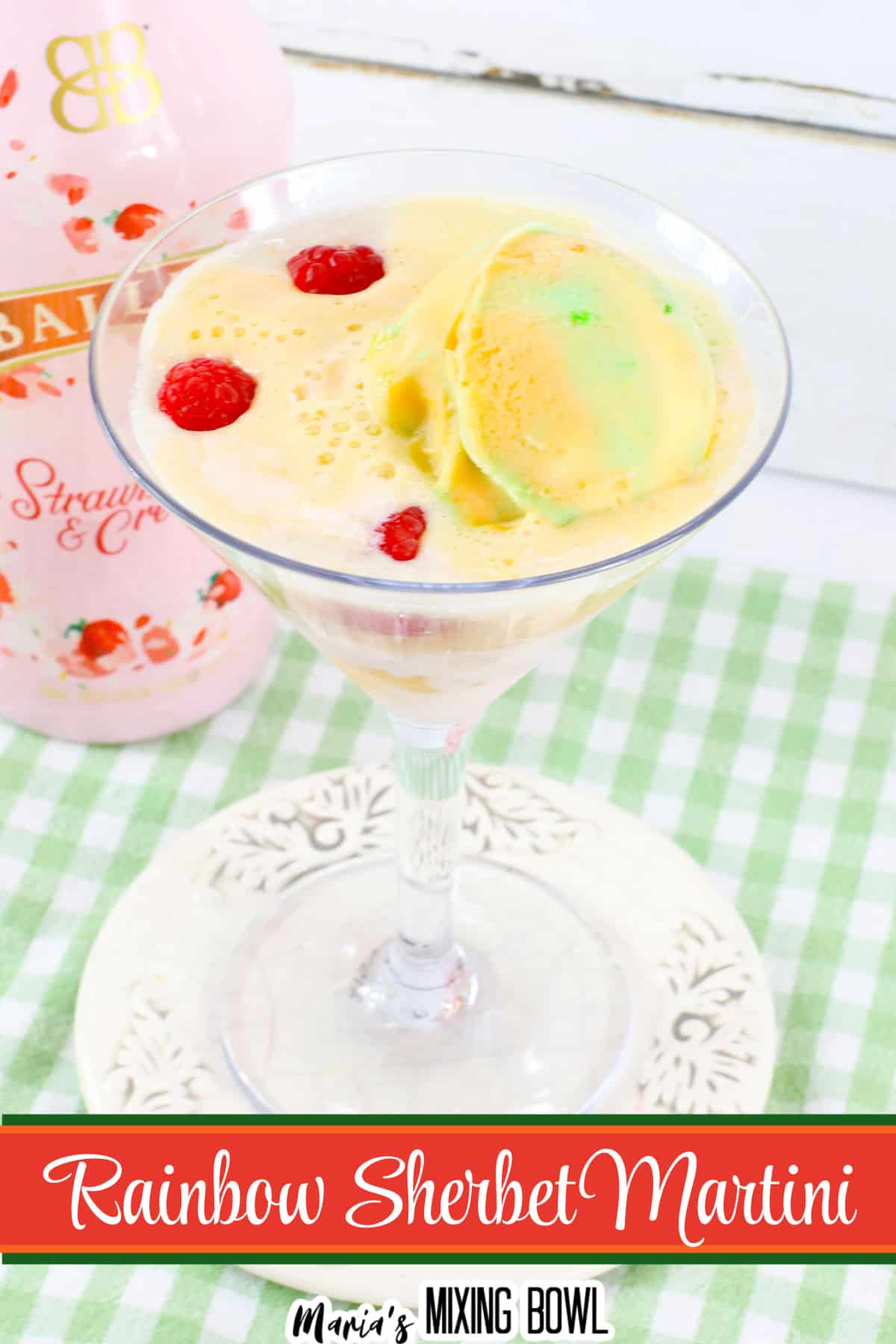rainbow sherbet martini in a martini glass on a small white plate.