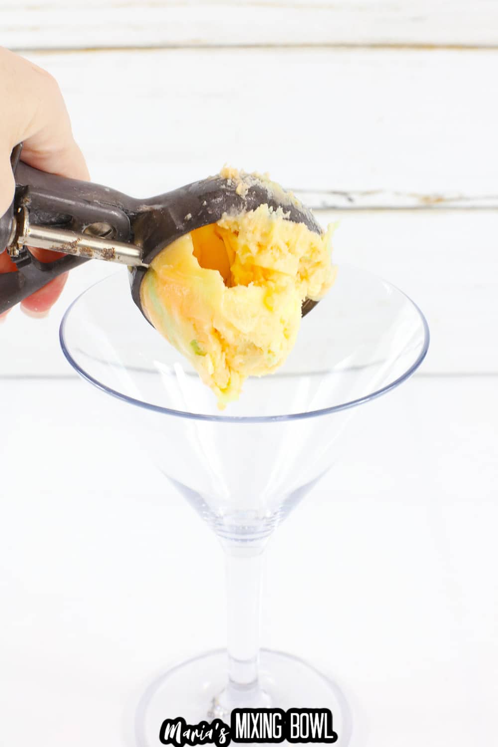 rainbow sherbet being scooped into a martini glass