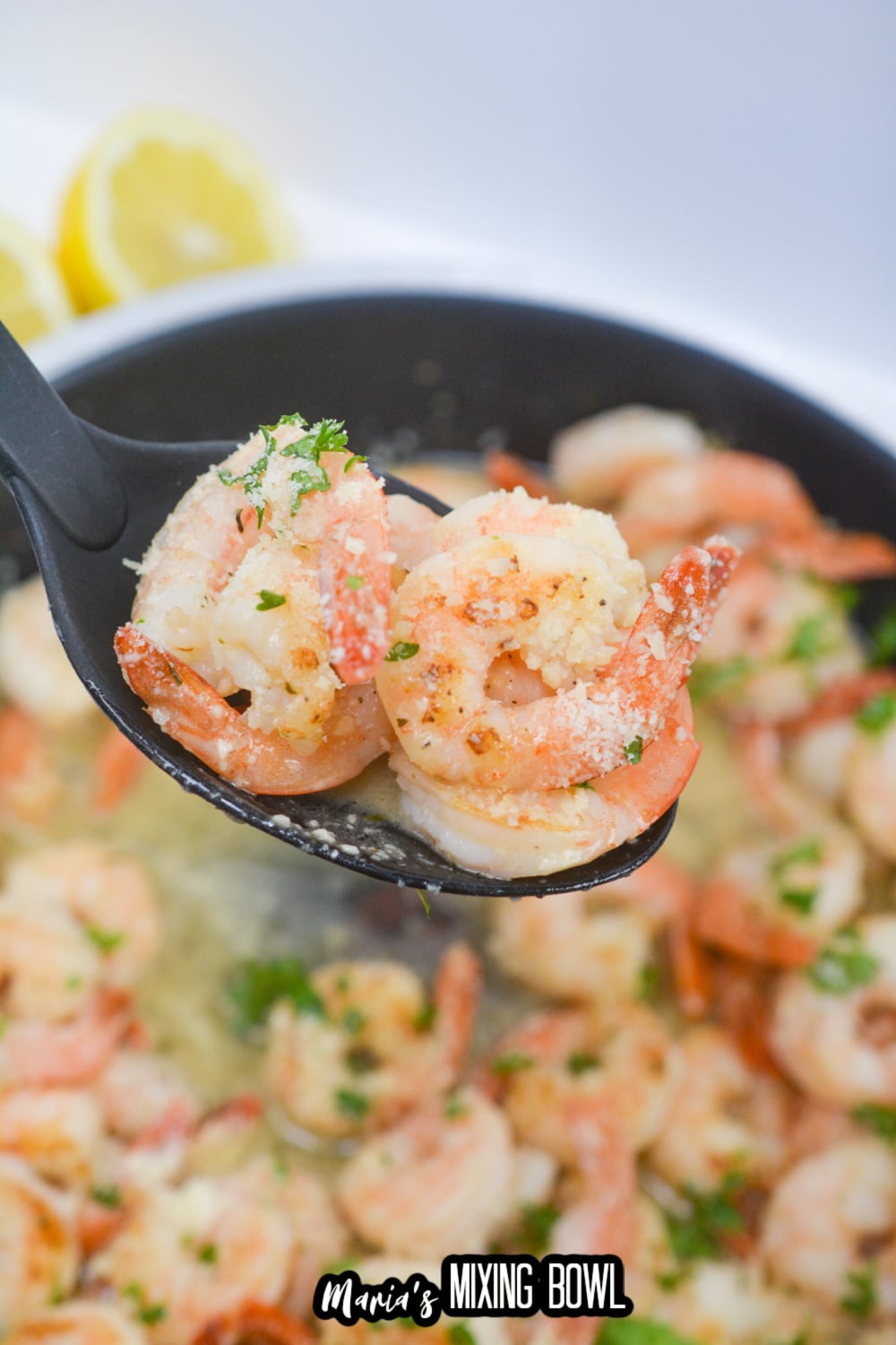 shrimp scampi on a rubber spoon held in the air