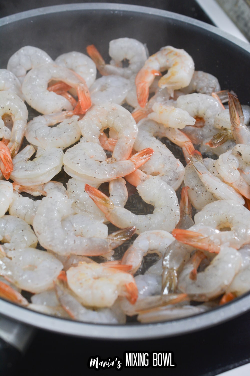 raw shrimp being cooked in a skillet
